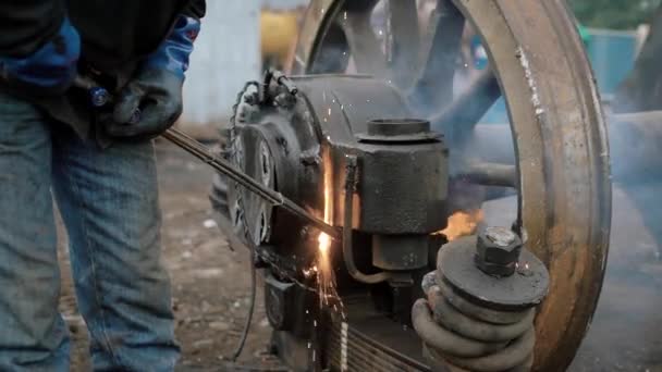 Plan rapproché des mains d'un homme en gants de caoutchouc qui coupe une partie du feu de la roue métallique d'un tramway ou d'un train , — Video