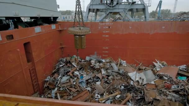 В большой контейнер с металлическим мусором падают железные детали, механическое здание магнит отправляет мусор в контейнер — стоковое видео