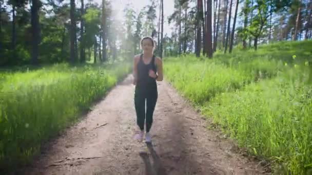 Donna attraente che fa jogging sul sentiero nel parco. Sport e ricreazione — Video Stock