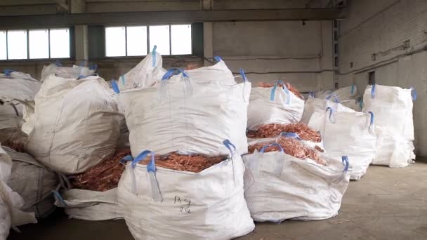 Enormes bolsas blancas con chatarra de cobre de los cables se encuentran en un almacén de la planta de procesamiento de chatarra — Vídeos de Stock