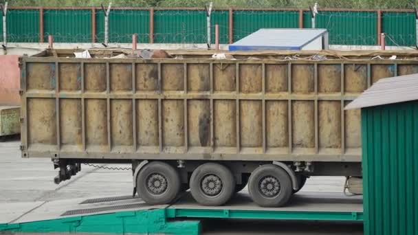 Duże ciężarówki załadowane z odpadów będzie w odwrotnej kolejności z platformy w podwórzu zakładu w ciągu dnia, recykling — Wideo stockowe