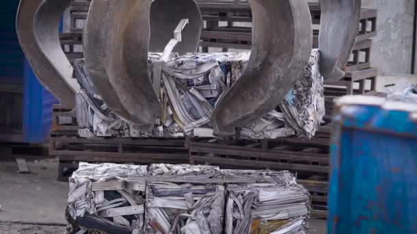 Борьба за лом стационарного релоадера - это установка сжатого металлолома в брикеты на поддоне под открытым небом в рабочий день — стоковое видео