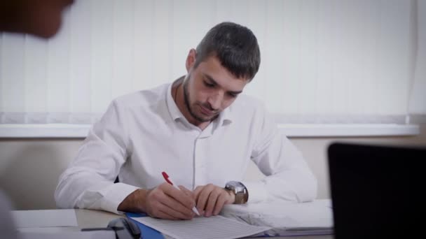 Elegante empleado de oficina masculino que trabaja en documentos importantes en el escritorio — Vídeos de Stock