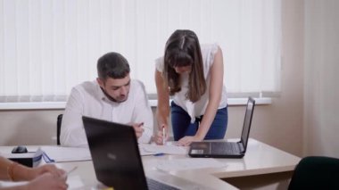 Genç meslektaşları ofiste birlikte çalışan önemli kağıt üzerinde işbirliği yapma