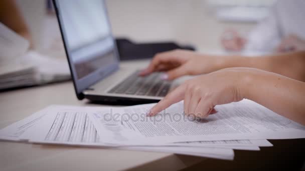Mujer de la cosecha escribiendo en el ordenador portátil y la lectura de papel cuidadosamente importante — Vídeo de stock