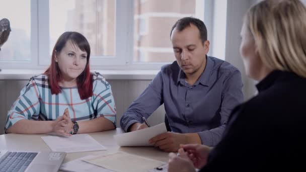 Pessoas que se reúnem à mesa na sala de conferências e trabalham com documentos — Vídeo de Stock