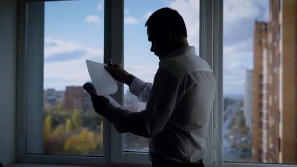 Hombre formal anónimo en la oficina leyendo cuidadosamente el archivo con documentos — Vídeos de Stock