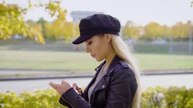 Yürüyüş smartphone kullanarak kentsel parkta genç şık modelinde