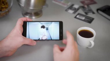Yakın çekim bir Video sahip adam. Mutfakta akşam, bir adam bir yaz tatili bir video izliyor. Video klip, güzel anılar. De dinlenme