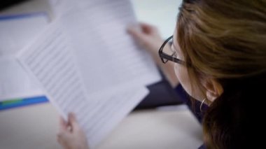 bir avukat kadın gözlük takan bir danışmanlık şirketi olan gündüz, hukukçu ofisinde belgelerde okuma