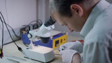 Elektronik mühendisi kırık ayrıntıları değiştirme mekanizması, tamir cep telefonu bir mikroskop altında incelenmesi