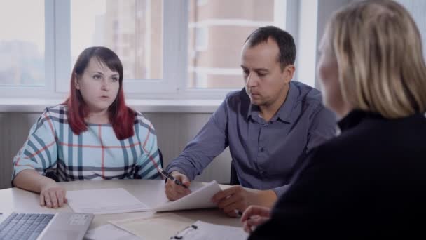 Couple adulte est assis sur une réunion dans le bureau de la société immobilière, à la recherche d'un spécialiste, discuter — Video