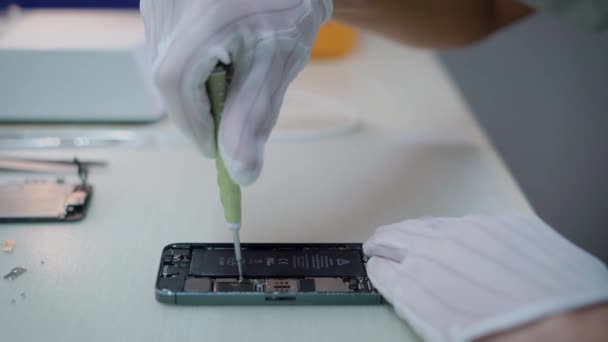 Ingeniero electrónico está torciendo los pernos dentro de un teléfono inteligente después de un examen telefónico independiente en caso de mal funcionamiento — Vídeo de stock