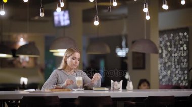 Çok güzel sarışın kadın bir kafede kahve içer.