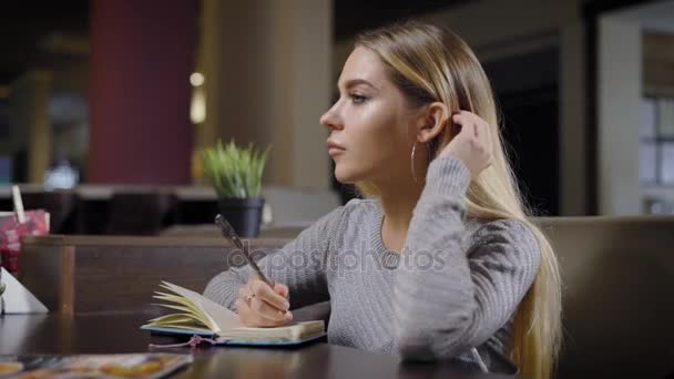 Krásná inteligentní žena tráví čas v kavárně psaní. — Stock video