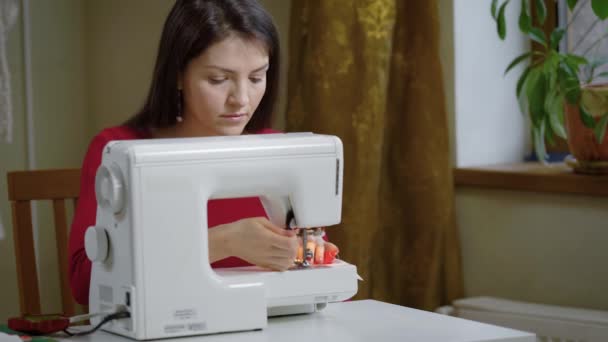Молодая швея работает на швейную машинку, дама шьет свою собственную одежду на заказ для своих клиентов — стоковое видео