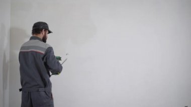 Ana bir duvara beyaz macun uygulama ve macun bıçak, gündüzleri Ev Tadilatı bir oda bulaşması