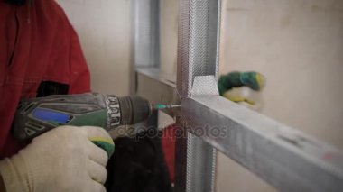adam elektrikli tornavida, cıvata içinde ev onarım sırasında alüminyum yapısı içinde büküm kullanıyor