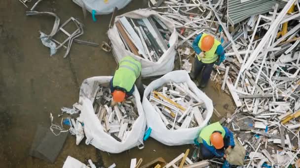 Vista superior de los trabajadores empacando basura metálica en bolsas grandes — Vídeos de Stock