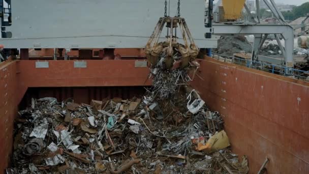 Grúa con imán en proceso de vertido de basura en contenedor — Vídeos de Stock