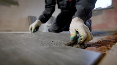 Çimentolu kat kiremit koyan inşaat işçisi yakından bakmak.