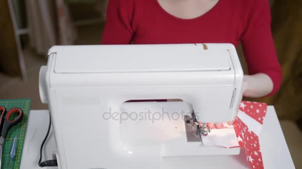 Adult brunette seamstress is stitching on a modern sewing machine in a work room, womens hobby in a home — Stock Video