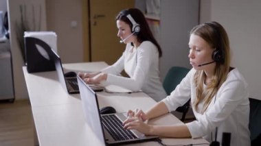 Birçok kadın laptop klavye, çağrı merkezi ofis mikrofon bayanlar konuşma metni yazdırmak, gelen aramaları yanıtlayacak ve müşterilerine bildirmek
