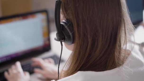 Mikrofon ve kulaklık ile çağrı merkezi müşteriler ile konuşan, kadının yüzüne yakın çekim o laptop çalışır — Stok video