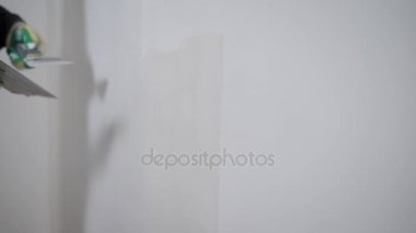 Kim uzun spatula ve sıva duvar seviye, Oluşturucu elinde bir yakın çekim adam kompozisyon yüzeyde geçerlidir