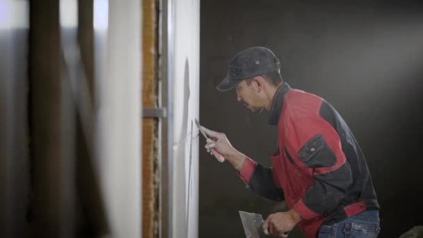 Професійний будівельник займається змішуванням швів біля плитки, щоб зробити дизайнерську стіну — стокове відео