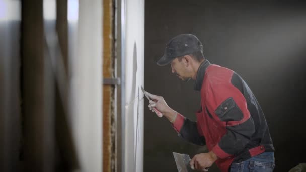 Un costruttore professionista è impegnato a schiacciare le cuciture vicino alla piastrella al fine di creare un muro di design — Video Stock