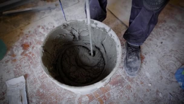 一个穿着建筑套装的人用电钻工作, 工人们在工地上种水泥来制造混凝土。 — 图库视频影像