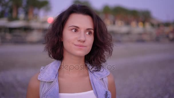 Випадкова молода жінка виглядає вдумливо, відпочиваючи на тропічному березі — стокове відео