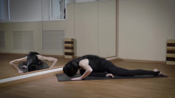 Esmer kadın fornt ayna mindere oturmuş yoga sınıfındaki germe. — Stok video