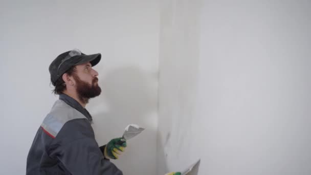 Contratista profesional trabajando y alisando yeso en pared con espátula — Vídeos de Stock