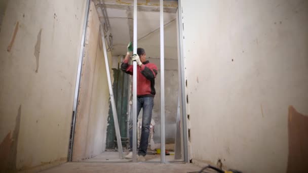 Muž překrývající kovových panelů při práci sám na staveništi — Stock video