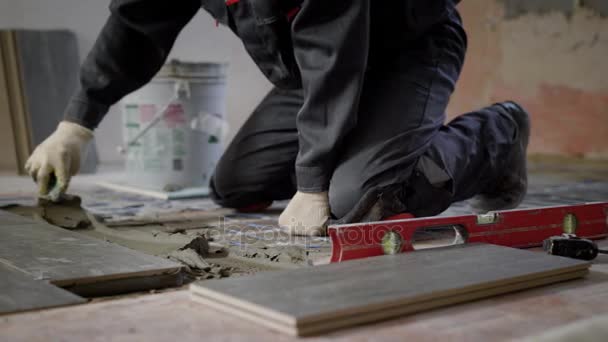 Construtor anônimo trabalhando no local e aplicando cimento no chão — Vídeo de Stock