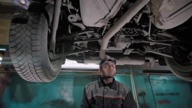 Bir araba bir atölyede şasi üzerinde profesyonel otomatik mekanik.