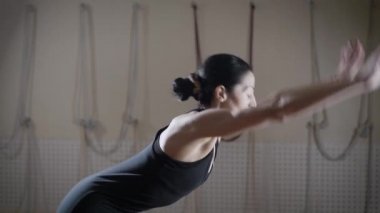 Bir spor takım, genç bir kadın çalışmaları gerçekleştiren bir bayan için esneklik, nişanlı Yoga mat