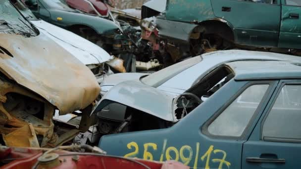 Primer plano de los coches que se encuentran en el vertedero de vehículos, un montón de chatarra que se utilizará para el reciclaje — Vídeos de Stock