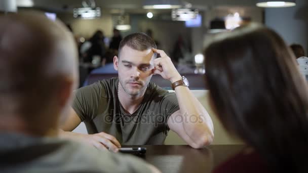 Concentré jeune homme écoute et parle avec ses amis dans un café, une réunion d'affaires de jeunes hommes d'affaires — Video