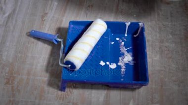 boya silindiri yalan bir düz bir zemin üzerinde mavi tepsisinde beyaz boya kovası, araçları ve malzemeleri tamir için akan