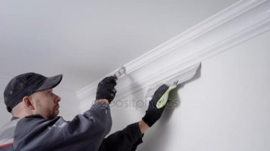 deneyimli ressam Süpürgelik, köşe tavan arasında sabitleme boyama ve beyaz, el ile doğum yapan bir tamir duvarlar