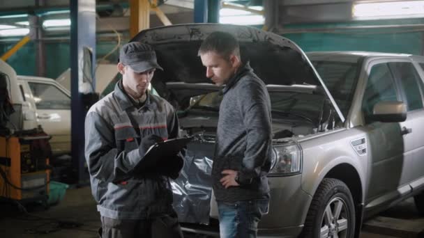 Mecánico de coche y cliente cerca de coche — Vídeos de Stock