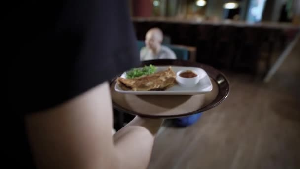 Zár megjelöl szemcsésedik, a pincér keze, aki a tálcát a frissen készített omlett, az edényt fel az asztalra, a látogatók — Stock videók