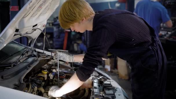 Twee mannen technicus onderhoud van auto in de werkplaats — Stockvideo
