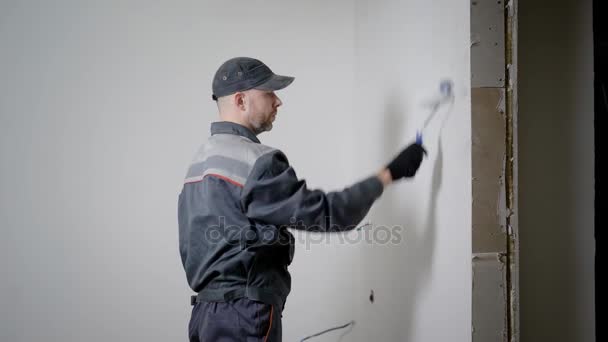 Reparateur dekoriert das Zimmer in der Wohnung. — Stockvideo