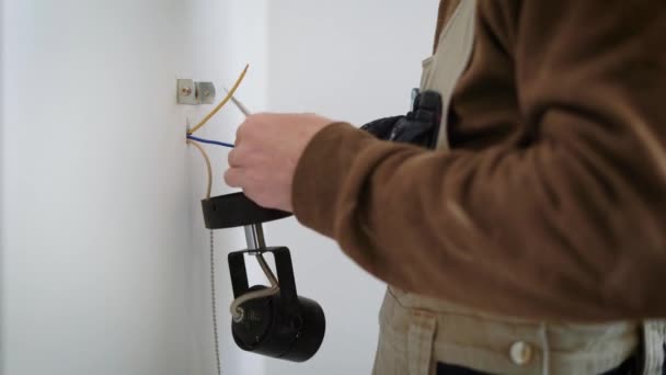 Close-up shot van de handen, die installeert de muur lamp in het appartement, mans de persoon het schroeven in de muur — Stockvideo