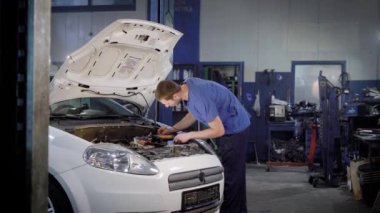 Adam bir servis merkezinde araba incelenmesi.
