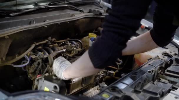 Nahaufnahme eines Ingenieurs, der den Deckel des Motors unter der Motorhaube entfernt. — Stockvideo